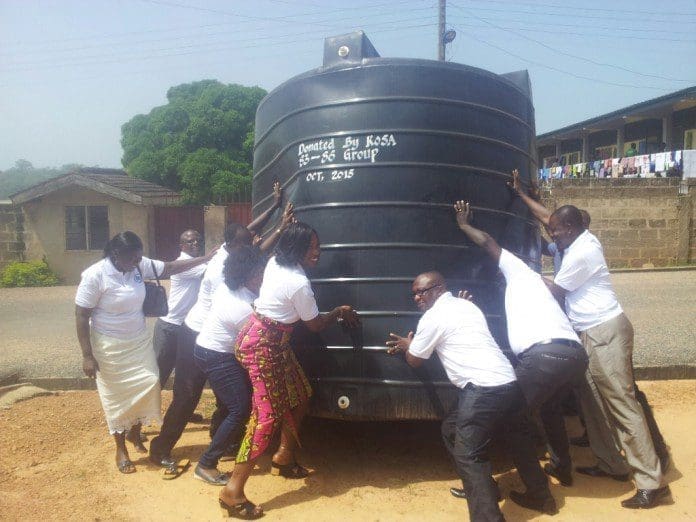 Old students of KPASEC lifting the 10,000 litre capacity water reservoirs