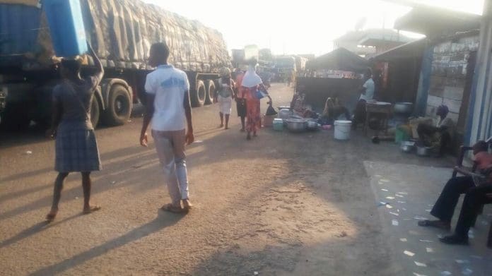 Some trader cooking close to vehicles at Yeji