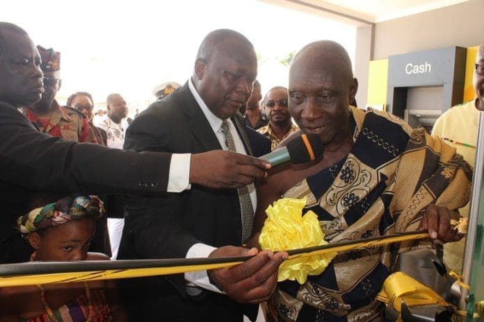 Mr Robert Adamu, Head of Support Services Department of GCB assisting the Paramount Chief of Tefle Traditional Area to commission the Sogakope branch of the Bank.