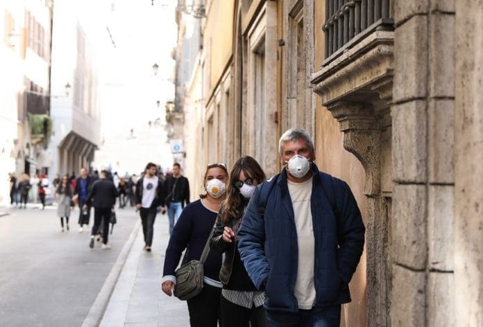 Pedestrians wearing face masks walk on a street in Rome, Italy, March 10, 2020. Italian Prime Minister Giuseppe Conte announced late Monday that the whole of Italy will be placed under lockdown from Tuesday until April 3. (Xinhua/Cheng Tingting)