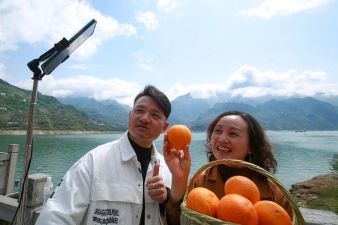 Employees of an e-commerce company in Yichang, central China’s Hubei province promote navel oranges produced in Zigui, a county in Yichang on a livestream platform of social app WeChat, April 19. They have sold 50,000 kilograms of the navel oranges. Photo by Wang Gang, People’s Daily Online
