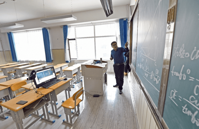 A teacher from a middle school in Lanzhou, west China's Gansu province teaches online in an empty classroom, March 30, 2020. By Ding Kai, People's Daily Online