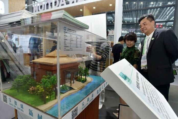 A model of an environmentally friendly log cabin is exhibited at the 15th International Conference on Green and Energy-efficient Building and New Technologies and Products Expo in Shenzhen, south China's Guangdong province on April 3. (Photo by Zhuang Wenbin/People's Daily Online)