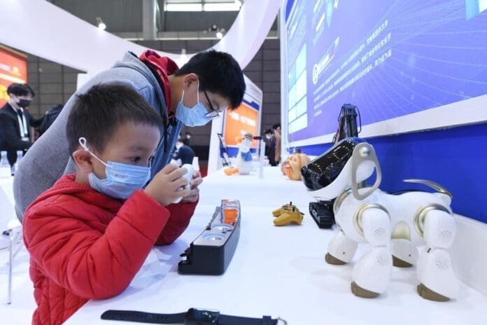 A child plays with smart toys exhibited at the exhibition area of the 2021 World Manufacturing Convention at the Hefei Binhu International Convention and Exhibition Center, east China’s Anhui province, Nov. 20, 2021. (Photo by Wang Biao/People’s Daily Online)
