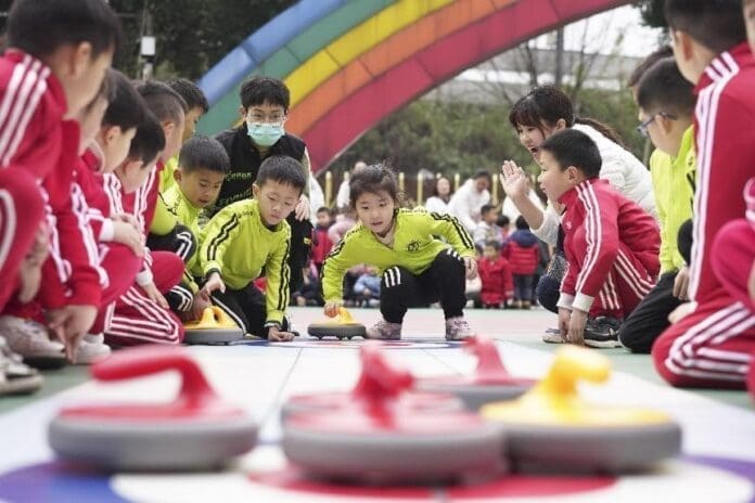 Children play floor curling under the instruction of teachers at a kindergarten in Beibei district, southwest China's Chongqing municipality, Feb. 16, 2022. (Photo by Qin Tingfu/People's Daily Online)