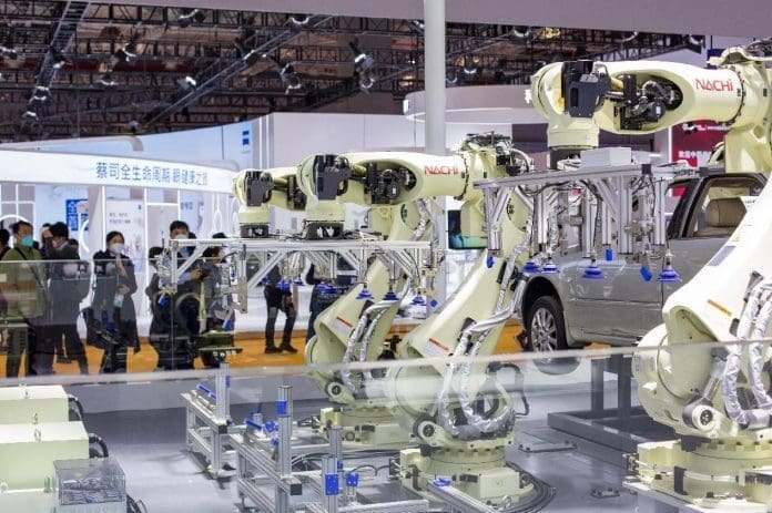 Vehicle-assembling robots are exhibited at the fifth China International Import Expo in Shanghai, Nov. 7, 2022. (Photo by Zhai Huiyong/People's Daily Online)
