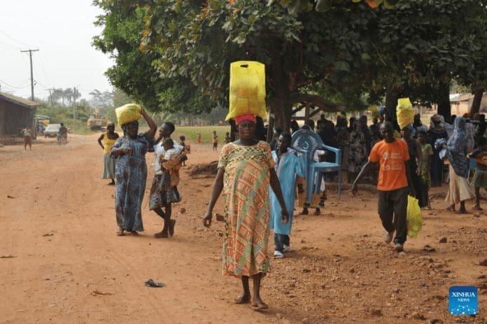 Local people fetch donated items in the Ashanti Region, Ghana, on Dec. 26, 2021. A Ghanaian charity and several Chinese companies on Sunday donated batches of daily necessities to worse-off communities in the Ashanti Region. (Photo by Seth/Xinhua)